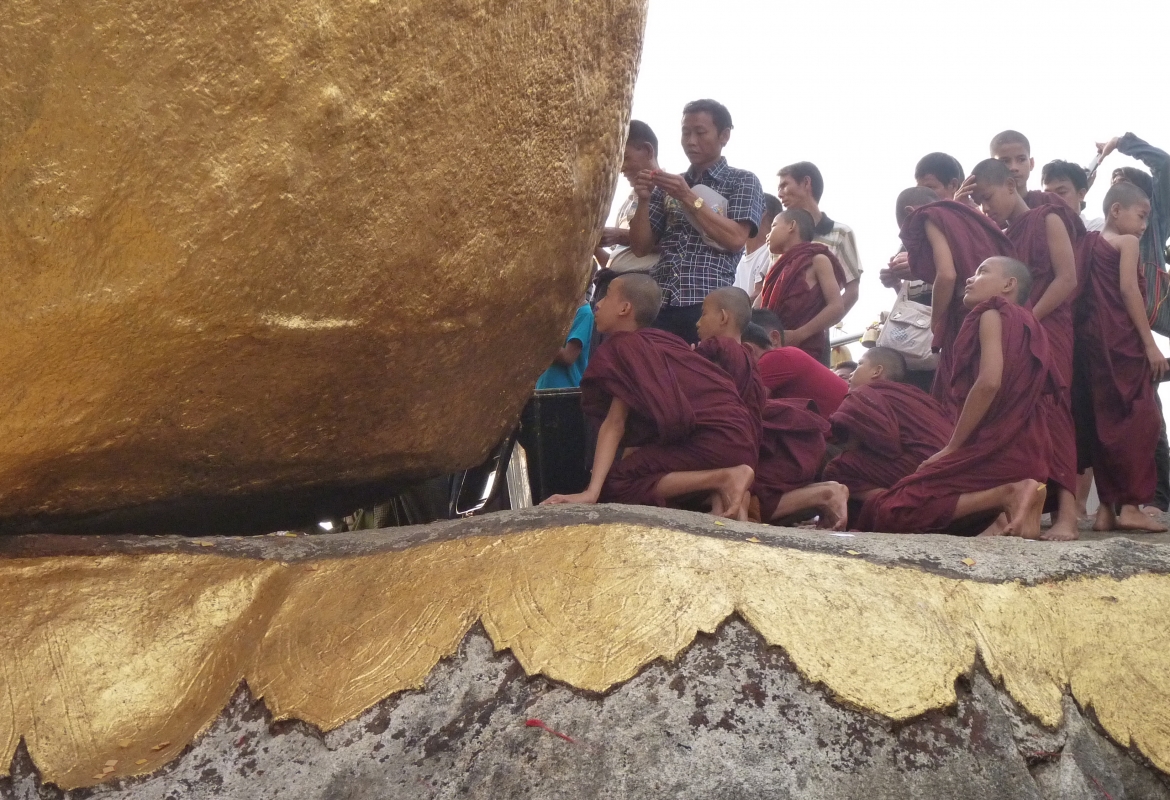 Mönche in Myanmar bekleben den „Golden Rock“, einen mystischen Felsbrocken,  mit Goldplättchen.